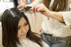 Young women are dyed the color of the hair in a beauty salon
